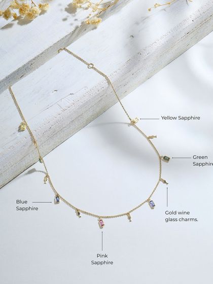 A detailed product shot of the multi-sapphire and wine glass charm necklace, labeling the different colored sapphires used in the design.
