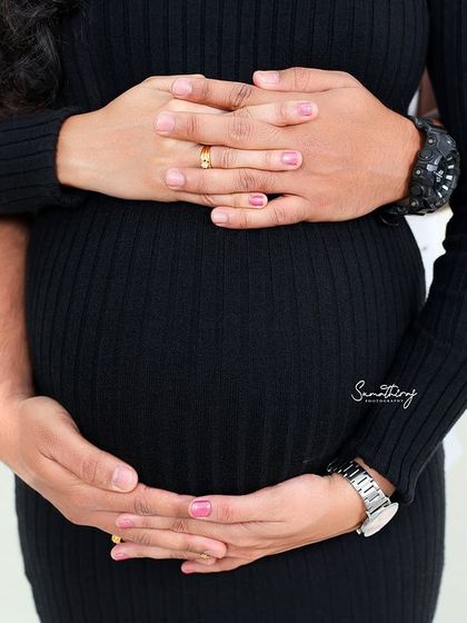 A close-up shot of a couple's hands cradling the baby bump. This simple yet profound image symbolizes the love, protection, and unity of the growing family.