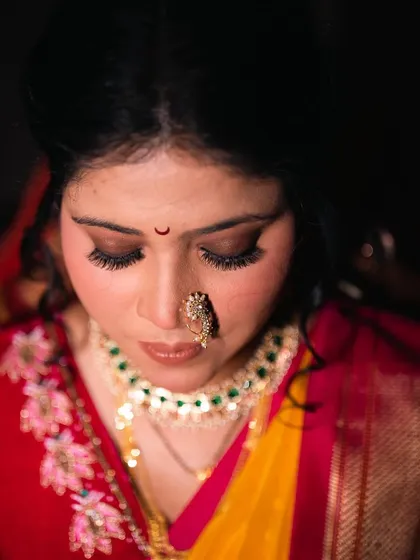 A top-down view highlighting the flawless eyeshadow blend and the traditional crescent moon bindi.
