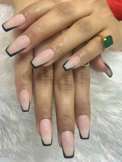 A modern and sharp take on the classic French manicure. We used long, coffin-shaped acrylic extensions with a clean nude base and a striking black tip to create a sophisticated, high-fashion statement.
