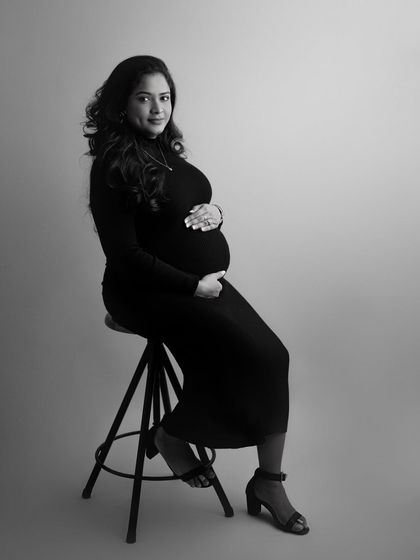 Simple, elegant, and classic. This seated black and white portrait of a mother-to-be in a simple black dress is the definition of understated grace.