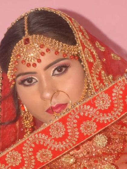A shy glance from behind the dupatta. This photo highlights the eye makeup and the traditional nath (nose ring).