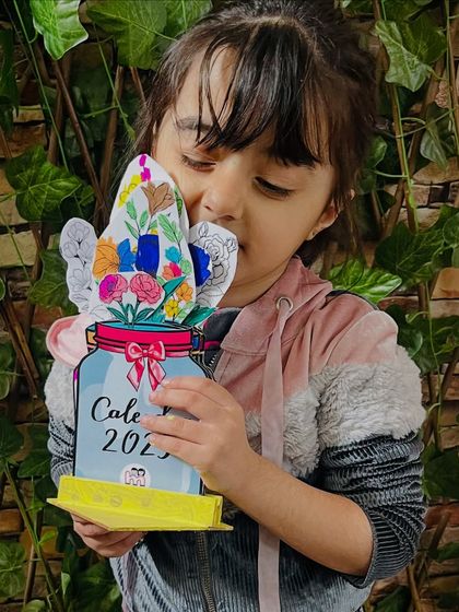 A student hugs the beautiful 2025 calendar she created in our New Year's workshop. It's a wonderful way to get creative and set intentions for the year ahead.