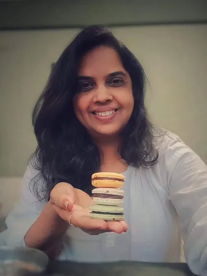 Here I am with a stack of my colorful, freshly baked eggless macarons. Baking is my passion, and I feel so much joy being able to share these sweet creations with you.