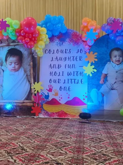 A fun Holi-themed birthday party with personalized photo panels. The backdrop is surrounded by an explosion of colorful balloons, creating a festive and playful atmosphere.