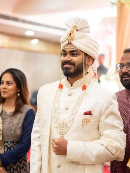 The groom waiting for his bride, with a young family member looking on.