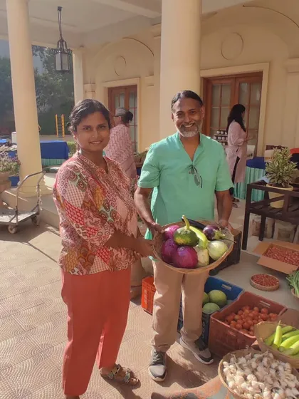 Manas and a farmer holding a basket of vegetables together, symbolizing the partnership.