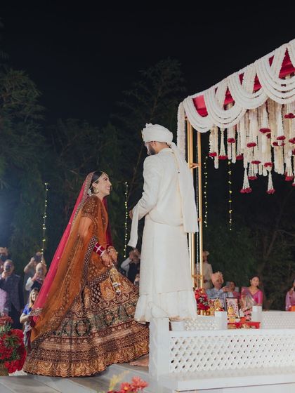 The bride makes her way to the mandap, a significant moment in every wedding. The elevated structure and grand floral design make the scene even more impactful.