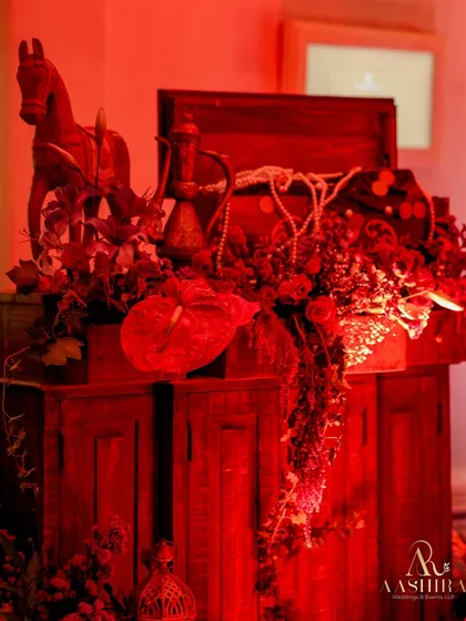 Another detail of the treasure corner, featuring a wooden horse, an Aladdin-style lamp, and cascading red florals.