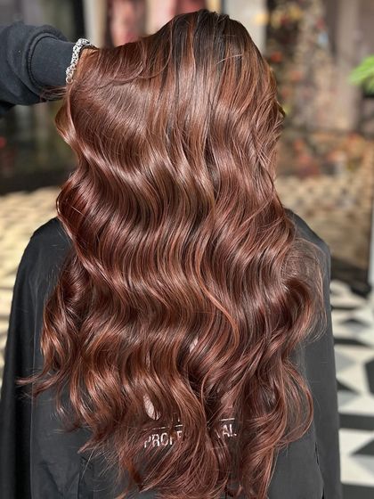 Shaping hair, shaping confidence. This long, wavy, reddish-brown look is absolutely stunning.