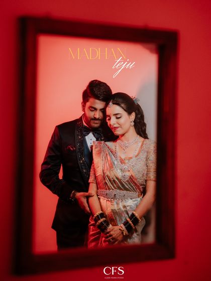 A creative portrait of the couple framed within a mirror, set against a bold red wall. This artistic approach adds a layer of depth and style to a reception photoshoot.