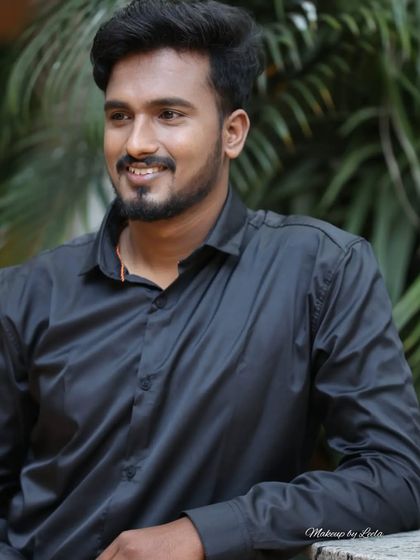 A close-up portrait of a male model. The grooming is natural, focusing on clear skin and defined features for a clean, professional look.