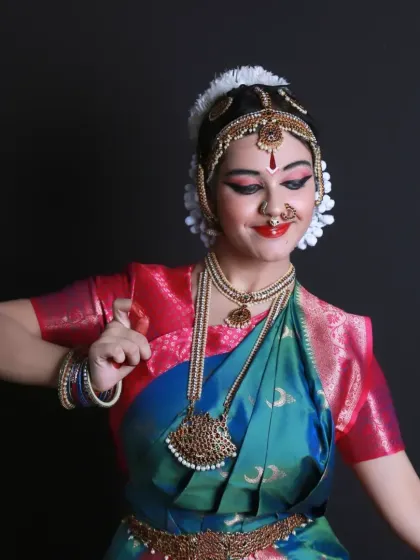 A joyful, candid shot of the young Bharatnatyam dancer. Her smile and dynamic pose capture the spirit and energy of the dance, even in a still photograph.