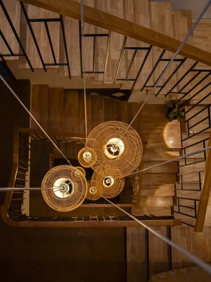 A view looking down the central stairwell, where a custom-designed cluster of cane pendant lights creates a cascade of warmth. This feature highlights my focus on vertical spaces and using lighting not just for function, but as a sculptural element that connects the home's different levels.