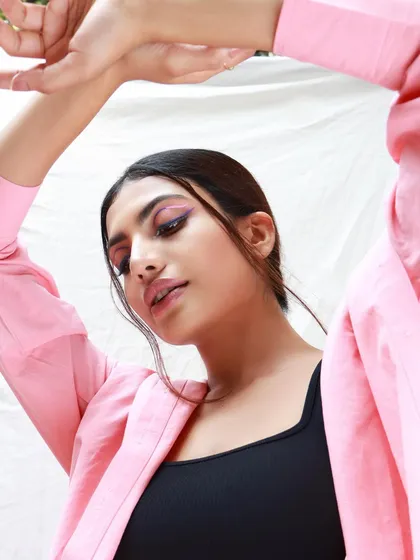 A close-up of the creative pink winged liner. This shot highlights the artistry and precision involved in creating a unique, editorial-style makeup look for a fashion brand.