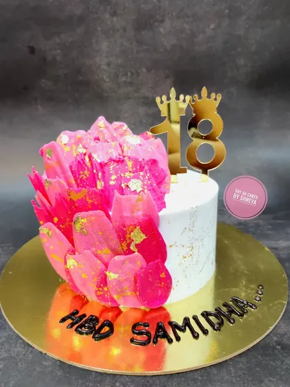 A vibrant and modern cake to celebrate an 18th birthday. The striking pink rice paper sail and gold leaf accents create a dramatic and stylish look for this important milestone.