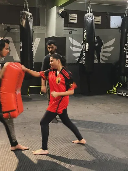 A female student practices her straight punch, demonstrating excellent form and power. Our training empowers everyone to be a capable fighter.