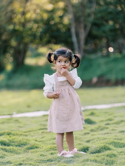A little girl in a field, looking curious. Capturing these moments of childhood wonder is a joy.