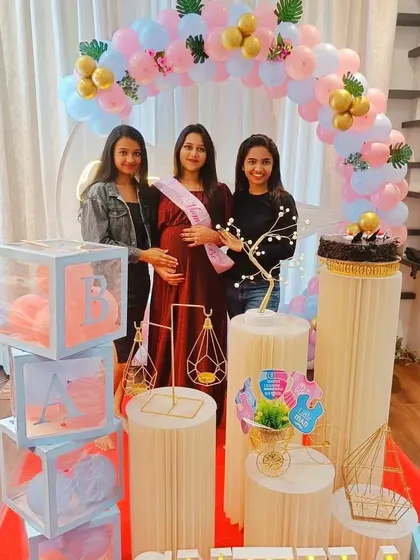 Happy guests at a modern baby shower. The pastel balloon arch and 'BABY' blocks make for a perfect photo backdrop.