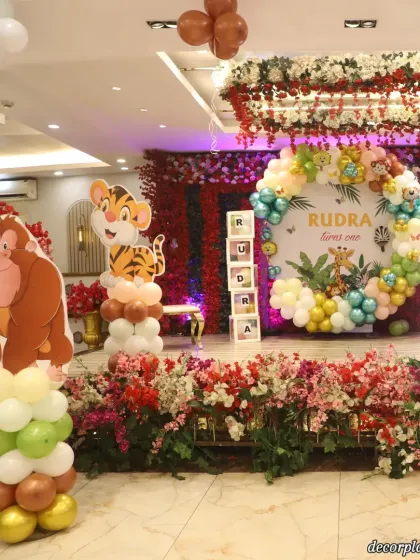 This angle highlights the cute animal character standees, like the gorilla and tiger, that bring the jungle theme to life. The floral arrangement at the base of the stage adds a touch of elegance.