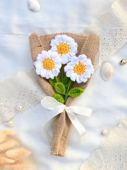 Three delicate crochet daisies bundled together in a rustic burlap wrap. This mini bouquet is perfect for a simple, sweet gesture.