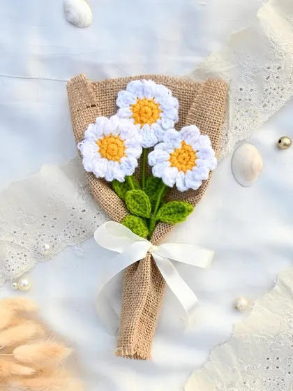 Three delicate crochet daisies bundled together in a rustic burlap wrap. This mini bouquet is perfect for a simple, sweet gesture.
