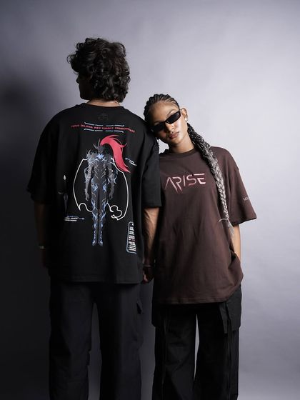 This image highlights the back graphic of the t-shirt, a key selling point for many streetwear brands. The models' connected pose creates a visually interesting composition that feels both stylish and intimate.