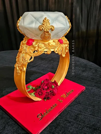 Another view of the sculpted engagement ring cake, highlighting the intricate gold detailing on the band and the beautifully crafted diamond.