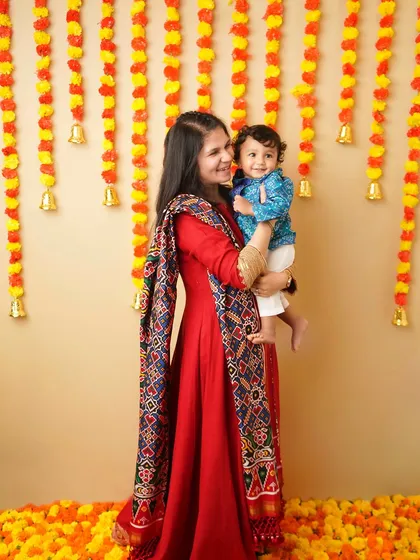 A mother holds her son during a festive Ganesh Chaturthi photoshoot. Including parents in milestone pictures makes the memory even richer.