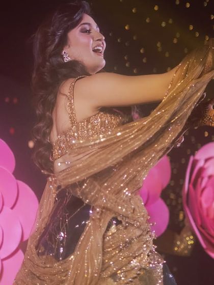A close-up shot capturing the bride's radiant energy during her dance. The stage was decorated with giant paper flowers to create a vibrant, floral-themed backdrop for her performance.