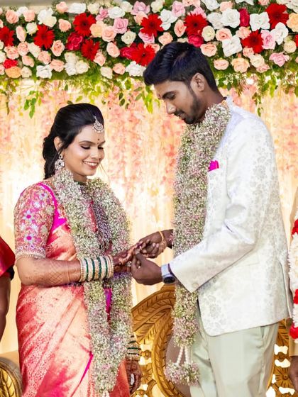 A candid moment from an engagement ceremony. The bride's pink silk saree is draped with neat, crisp pleats that stay in place, allowing her to enjoy her special moments without any worry.