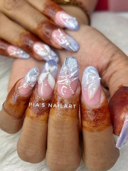 Another angle of these modern bridal extensions, showing how the design flows across each nail for a cohesive and stunning look against the client's henna.