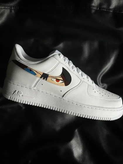 A side profile of the Sasuke custom sneaker, featuring his Rinnegan and Mangekyo Sharingan in the swoosh.