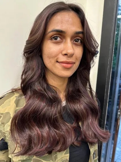The front view of our 'wine on brown' color, showing how the soft waves and face-framing layers work together with the subtle red tones to create a warm, flattering look.