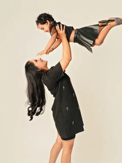 Pure, unfiltered joy! A mother lifting her daughter into the air is more than just a photo; it's a feeling of flight, freedom, and the incredible strength of a mother's love. These are the playful moments that define childhood.