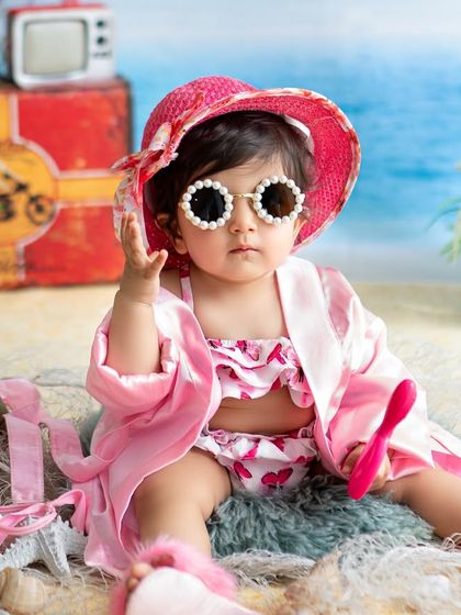 This little diva is ready for the sun in her stylish hat and pearl-rimmed sunglasses. The beach theme is perfect for capturing a fun, vacation vibe.