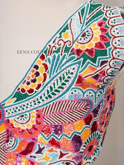 I designed this unique 'Butterfly Garden' blouse for the bride who loves color and artistry. The entire piece is covered in a vibrant mosaic of multi-colored beads and sequins, forming a stunning butterfly motif across the back.