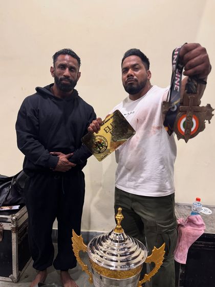 Holding the medals and trophy with my student. His victory is my victory.