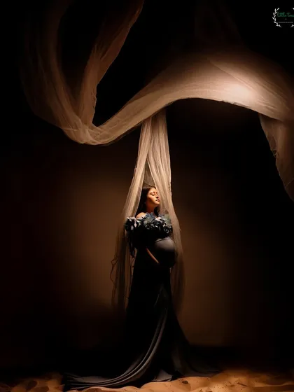 An ethereal portrait using flowing fabric and dramatic lighting to create a sense of movement and grace.