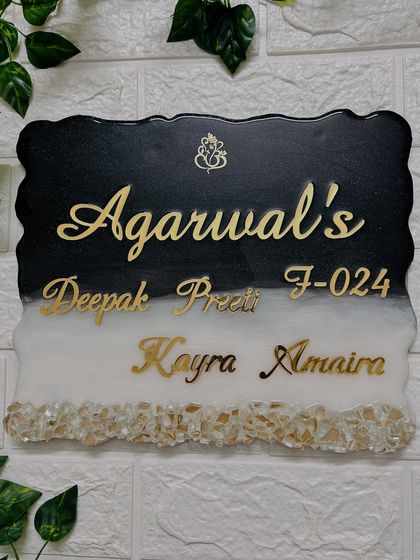 Elegance in black and white. This custom resin nameplate features a geode edge, a Ganesha motif for blessings, and the family's names in beautiful gold script.