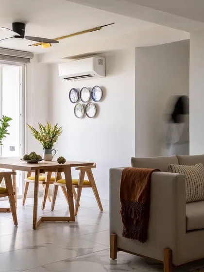 This modern dining space combines natural wood furniture with a light, neutral color scheme for a Scandinavian-inspired aesthetic. The decorative wall plates add a touch of personality and artistry to the minimalist design.