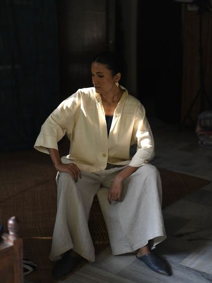 A quiet, contemplative shot for House of Wandering Silk. The play of light and shadow highlights the simple elegance of the outfit.