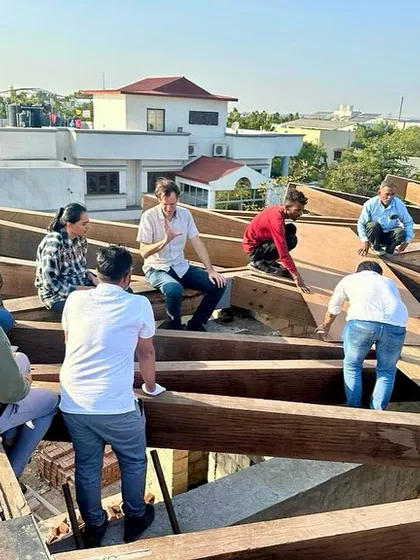 On-site discussions are a critical part of our process. Here, our team is on the roof of the House of Galleries, reviewing the timber framework with the craftsmen to ensure precision.