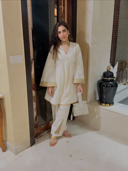 A Rakhi fit check in a beautiful off-white short Anarkali with salwar. The gold border detailing adds a touch of festive elegance.