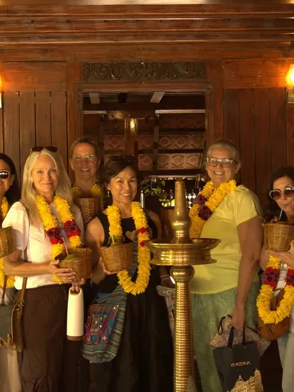 Our group of guests from the USA and France, all smiles after their traditional welcome. They are holding baskets, ready to embark on their personalized Ayurvedic wellness programs.
