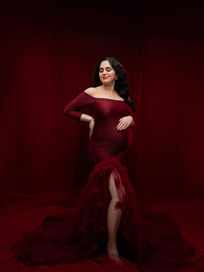 A serene pose in the red gown, capturing the peaceful anticipation of motherhood. The way the light falls on the fabric highlights the texture and rich color.