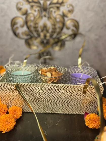 Our 'Goldy' hamper for Diwali, featuring three small crystal jars in a beautiful basket. You can customize the contents with candles, dry fruits, or chocolates.