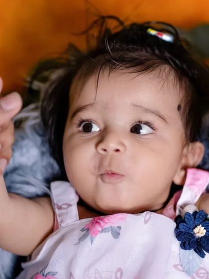 Chubby cheeks and curious eyes! This adorable close up captures the sweet and inquisitive nature of a toddler, a precious memory for any parent.