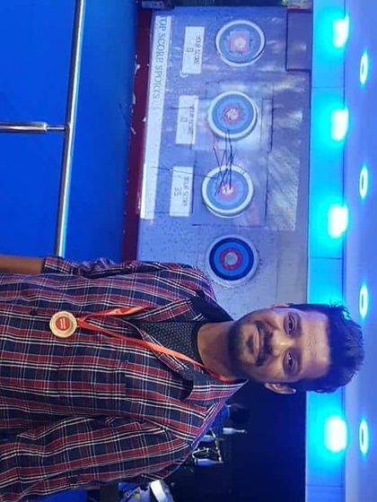 Posing with his medal in front of the targets he conquered. Our digital scoring system, visible in the background, makes it easy to see your score.