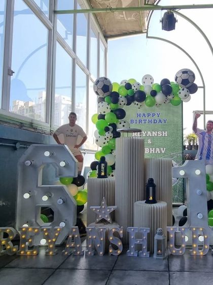 A full view of the rooftop football-themed party, showing the impressive scale of the marquee numbers.